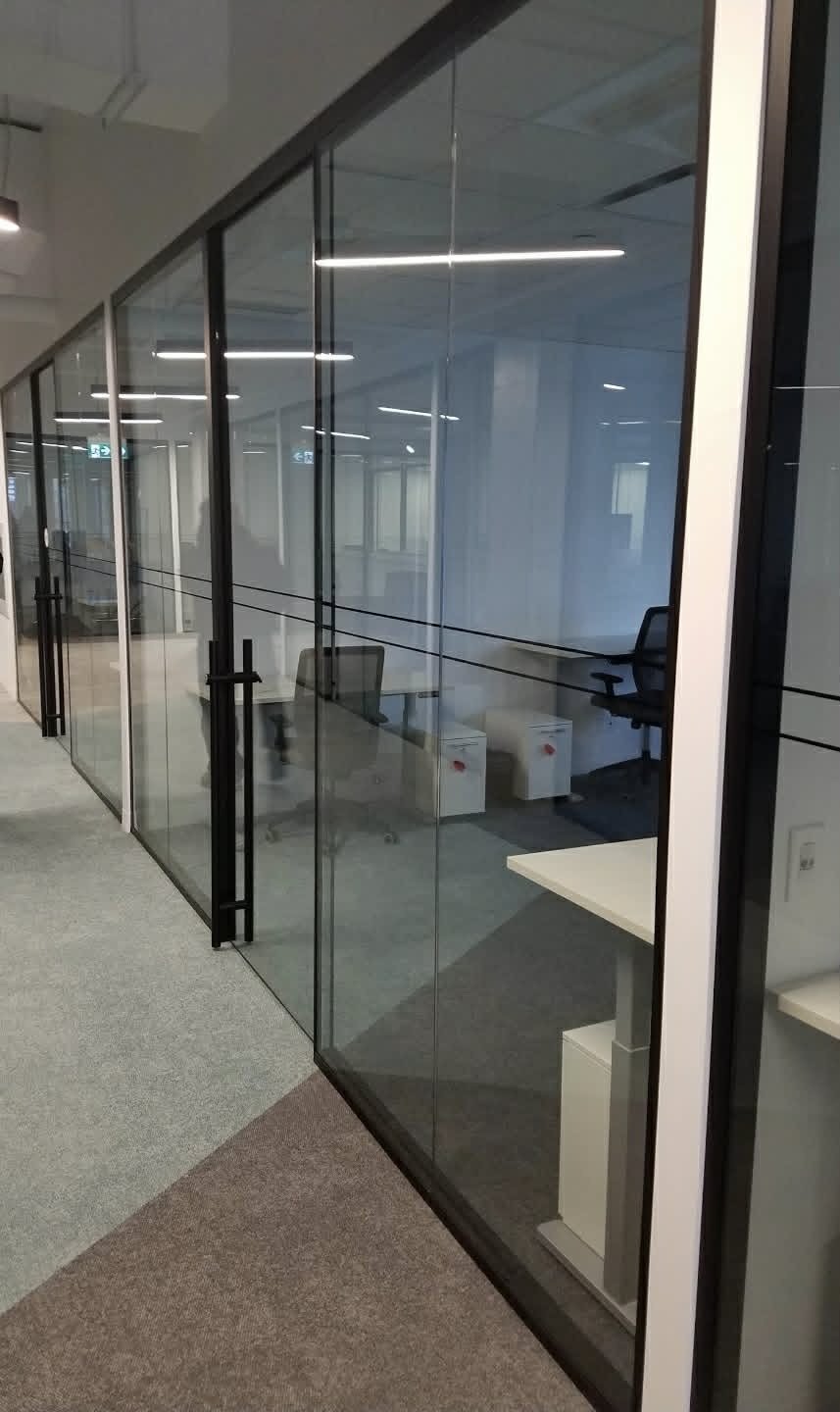 Glass-walled private office with black frames installed by SOIS
